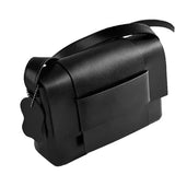A black leather handbag with a flap closure and a small tag attached to it.