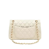A white quilted leather handbag with a gold chain strap.