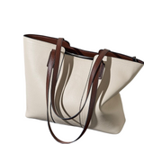 A tan leather tote bag with brown leather straps and a zipper closure.