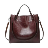 A burgundy leather tote bag with a curved handle and two shoulder straps.