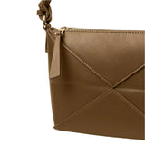 A close-up view of a brown leather handbag with a zipper closure and a small handle.