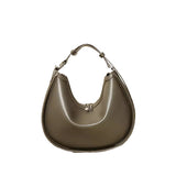 A brown leather handbag with a curved shape and a handle.