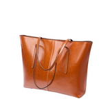 A brown leather tote bag with a curved handle and two straps, set against a white background.