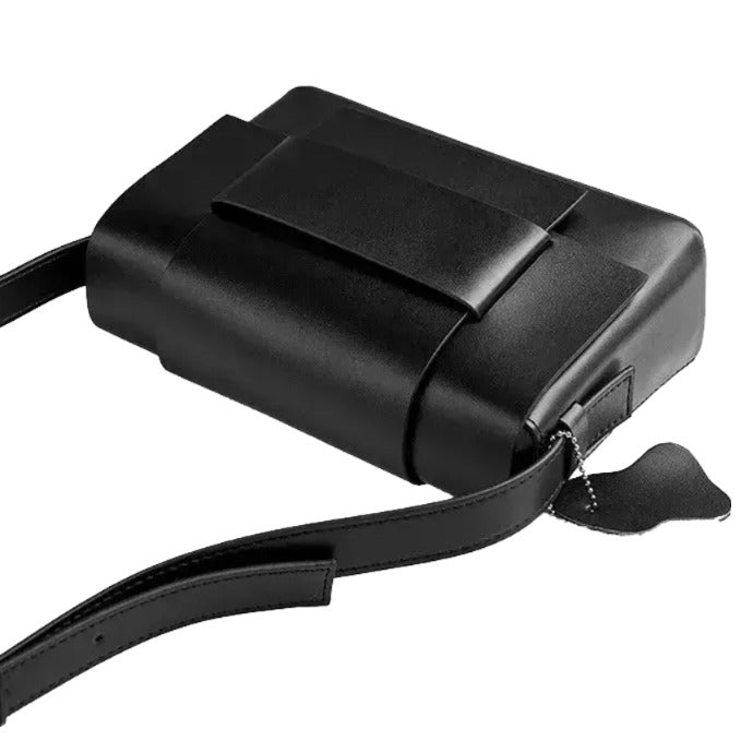 A black leather handbag with a strap and a small tag attached to it.
