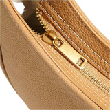 A close-up view of a tan leather handbag zipper with a gold zipper pull.