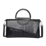 A black leather handbag with a unique snake skin texture and a curved handle.
