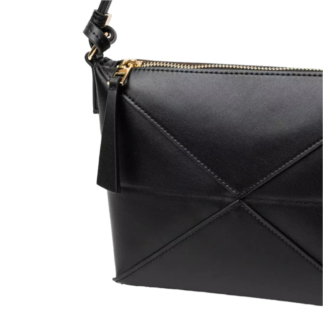 A close-up view of a black leather crossbody bag with a zipper closure and a tassel.